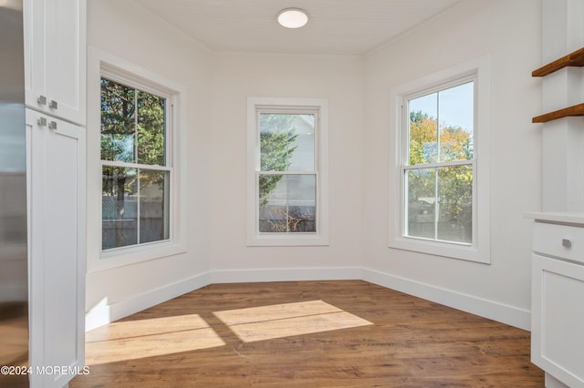 unfurnished dining area featuring hardwood / wood-style floors and a healthy amount of sunlight