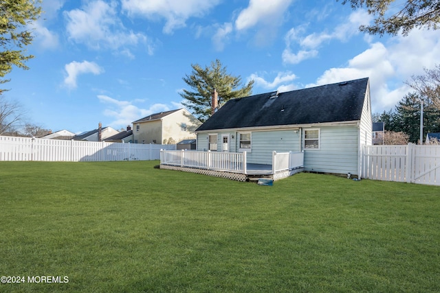 rear view of property with a yard and a deck