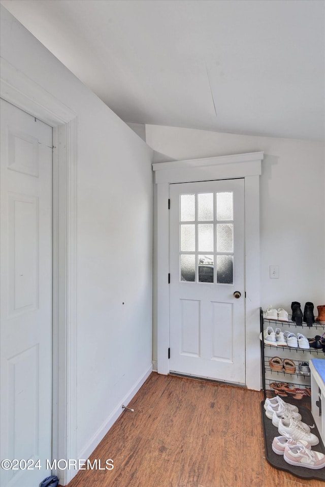 doorway with vaulted ceiling and wood-type flooring