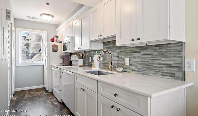 kitchen with white appliances, sink, dark hardwood / wood-style flooring, white cabinets, and light stone counters