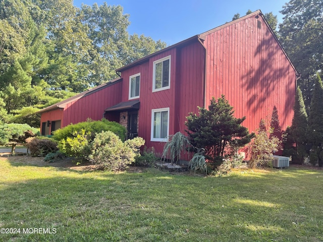 view of side of property with cooling unit and a yard