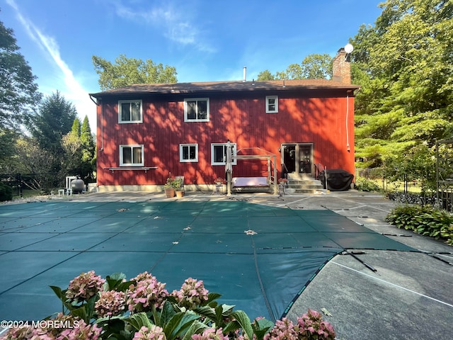 back of house with a patio area and a covered pool