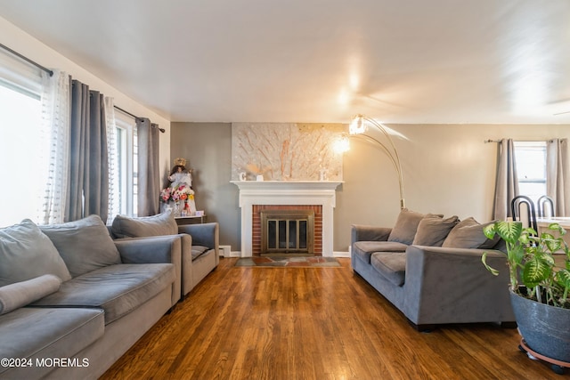 living room featuring dark hardwood / wood-style floors and a brick fireplace