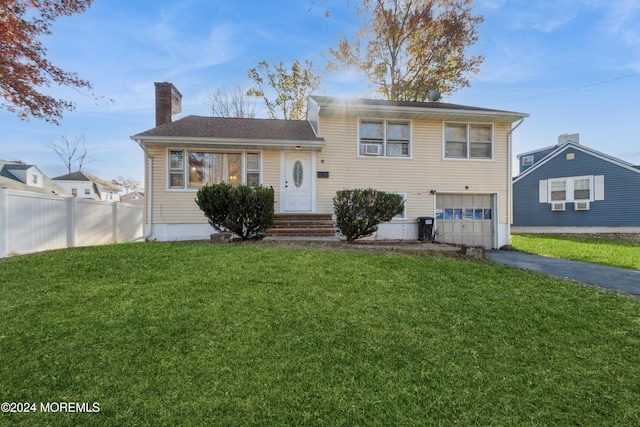 split level home with a garage and a front lawn