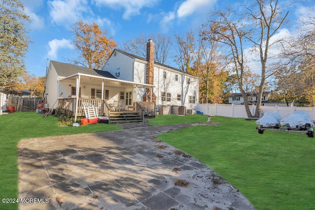 back of house featuring covered porch and a lawn