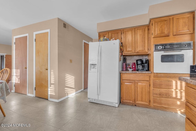 kitchen featuring white appliances and tasteful backsplash