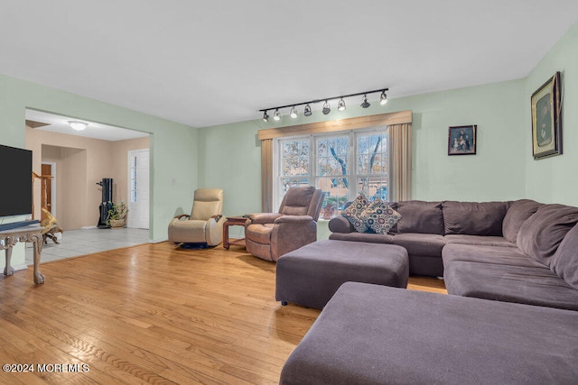 living room featuring rail lighting and light hardwood / wood-style flooring