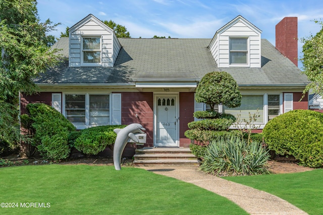 cape cod-style house with a front yard