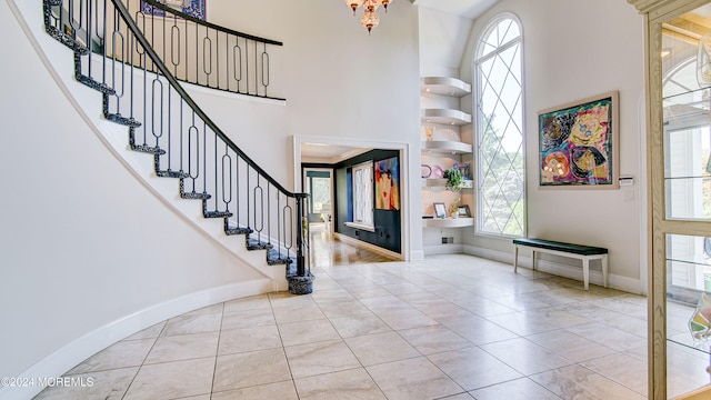 foyer with light tile patterned flooring, a high ceiling, and a wealth of natural light