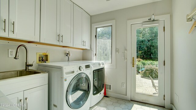 laundry room with washer and clothes dryer, sink, and cabinets