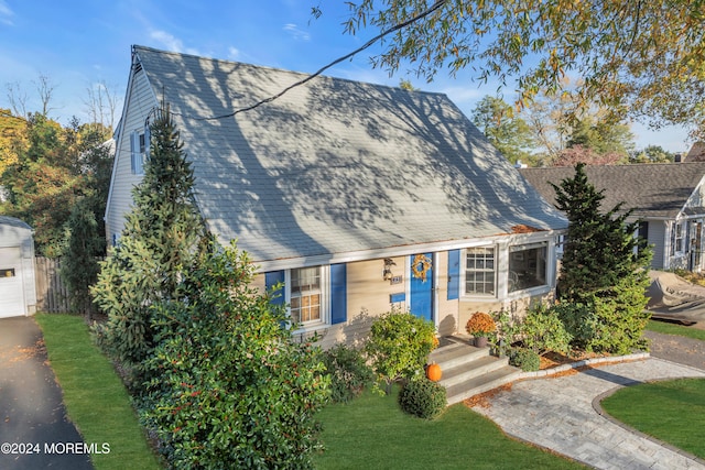 cape cod house featuring a front lawn