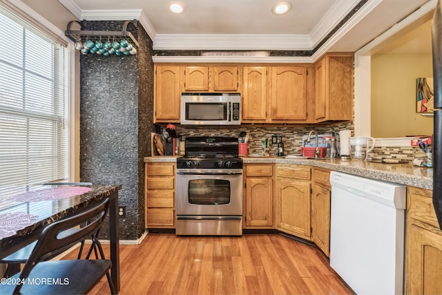 kitchen featuring appliances with stainless steel finishes, decorative backsplash, light hardwood / wood-style floors, and crown molding