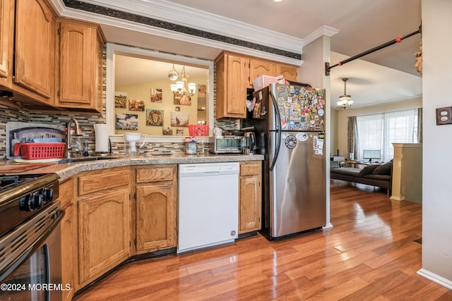 kitchen featuring stainless steel appliances, sink, a chandelier, pendant lighting, and light hardwood / wood-style flooring