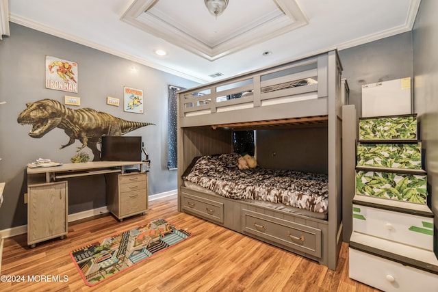 bedroom with a tray ceiling, light hardwood / wood-style floors, and crown molding