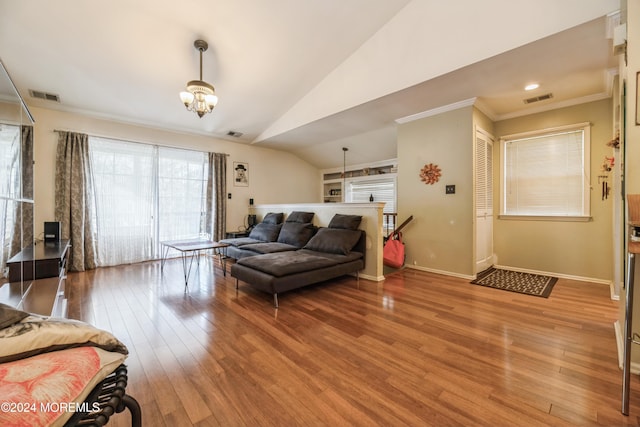 living room featuring crown molding, hardwood / wood-style flooring, a chandelier, and vaulted ceiling