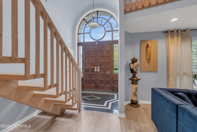 entrance foyer with light hardwood / wood-style floors and a towering ceiling