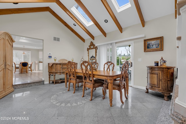 dining space featuring beam ceiling, high vaulted ceiling, and a skylight