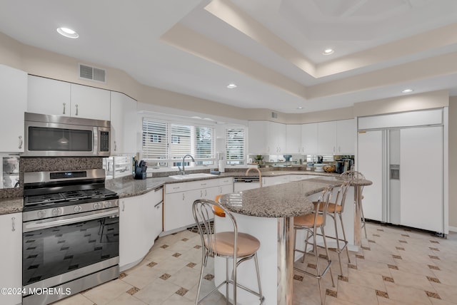 kitchen featuring sink, white cabinetry, stainless steel appliances, and dark stone countertops