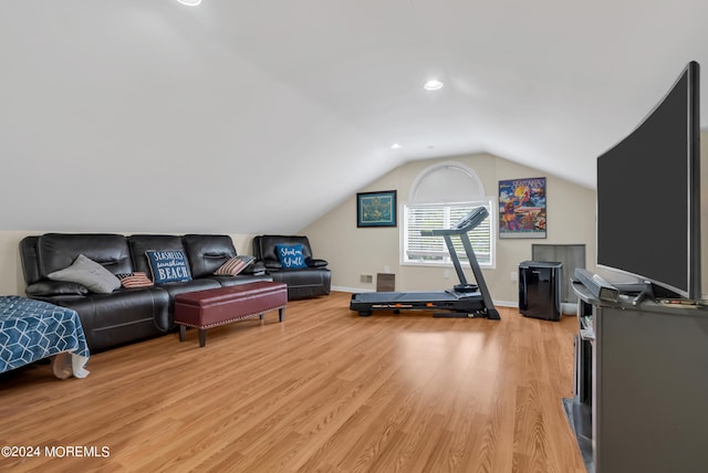 exercise area with vaulted ceiling and light hardwood / wood-style flooring