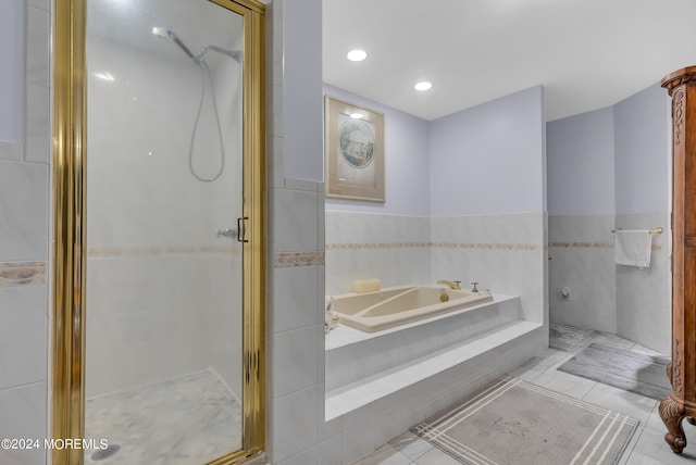 bathroom featuring shower with separate bathtub, tile patterned floors, and tile walls