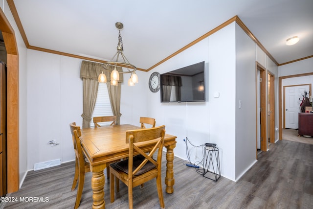 dining area featuring ornamental molding, a chandelier, and dark hardwood / wood-style flooring