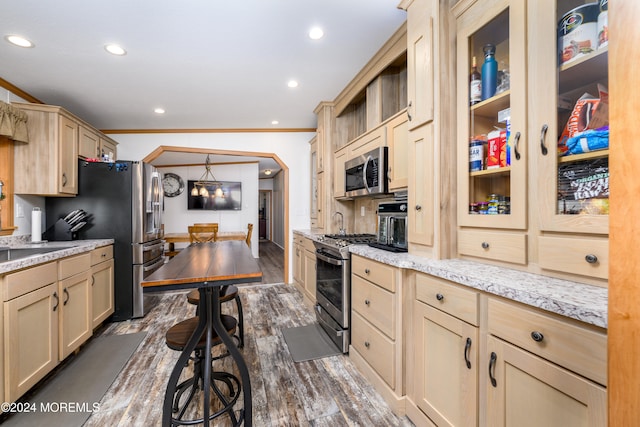 kitchen featuring light stone countertops, stainless steel appliances, dark wood-type flooring, ornamental molding, and light brown cabinets