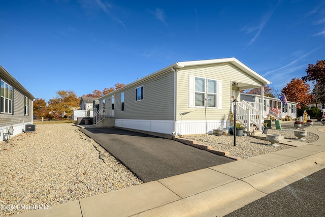 view of side of property with central air condition unit and a patio area