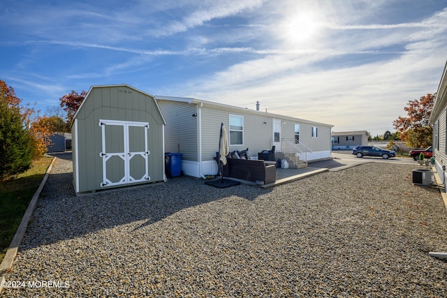 back of house with a storage unit, a patio, and central AC unit