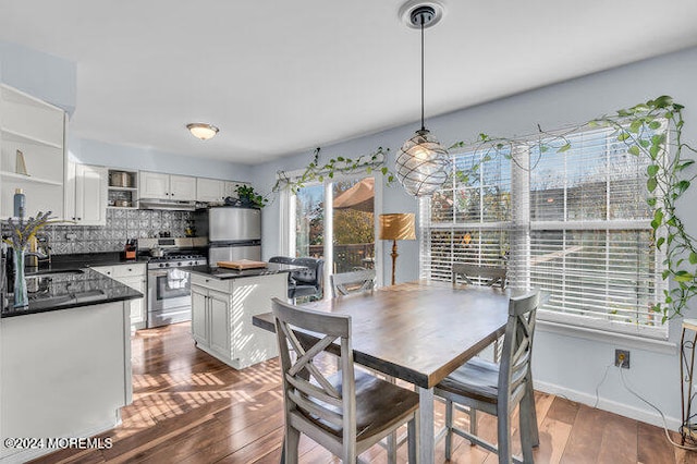 dining space with dark hardwood / wood-style flooring and sink