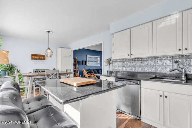 kitchen with stainless steel dishwasher, a kitchen breakfast bar, white cabinets, and pendant lighting