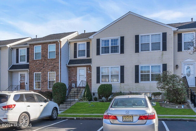 townhome / multi-family property featuring a front yard