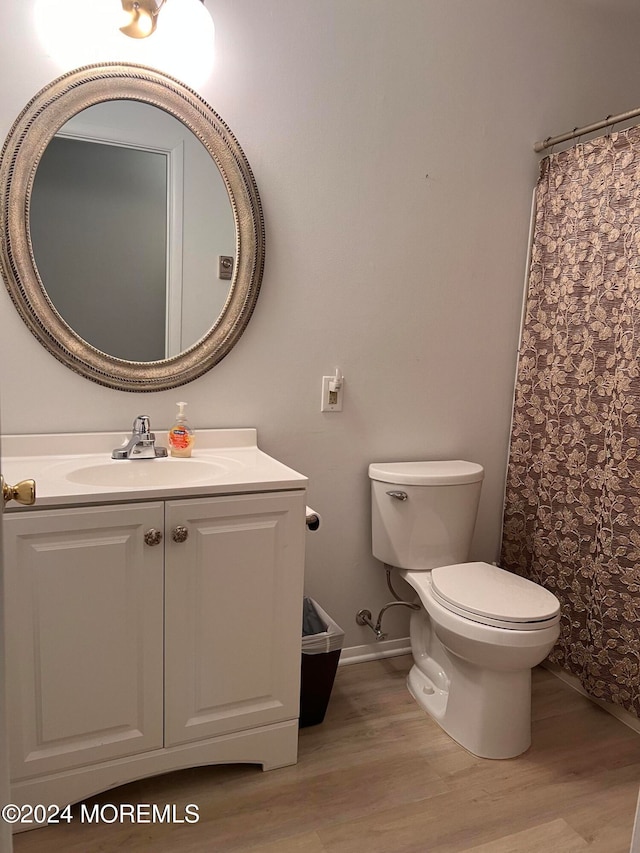 bathroom with vanity, hardwood / wood-style flooring, and toilet