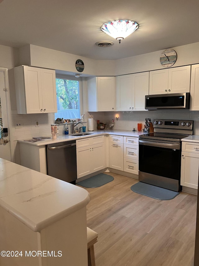 8A Fallbrook St, Whiting, NJ 08759 - kitchen with appliances with stainless steel finishes, a sink, tasteful backsplash, and white cabinets