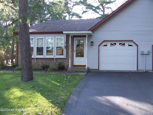 single story home featuring a garage and a front lawn