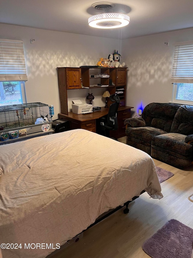 bedroom with light hardwood / wood-style flooring and multiple windows