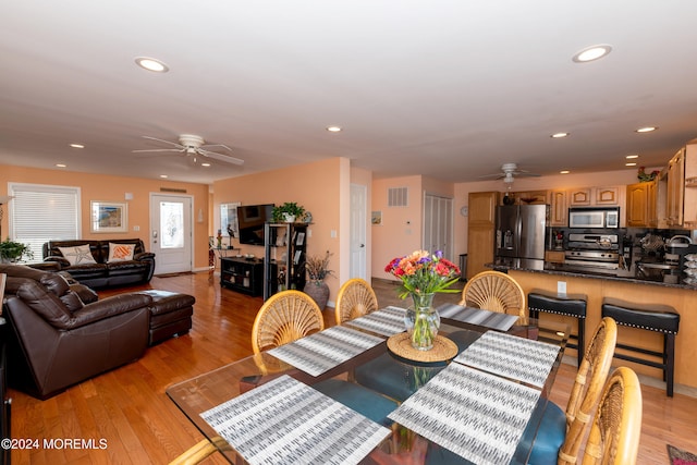 dining space with ceiling fan and light wood-type flooring