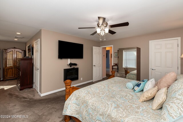 bedroom featuring ceiling fan and dark carpet