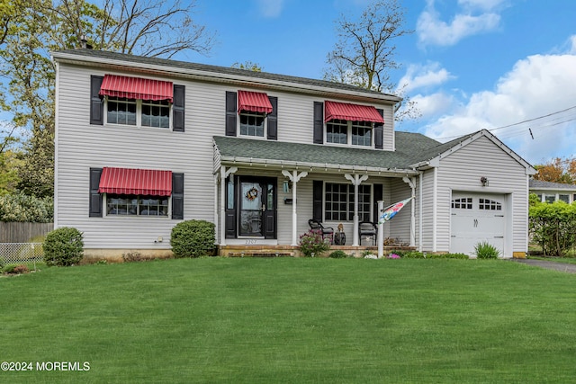 view of front of house with a porch, a front yard, and a garage