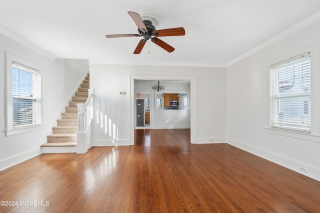 unfurnished living room with ceiling fan with notable chandelier, hardwood / wood-style flooring, and crown molding