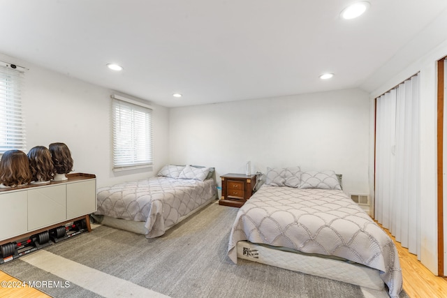 bedroom with lofted ceiling and light wood-type flooring