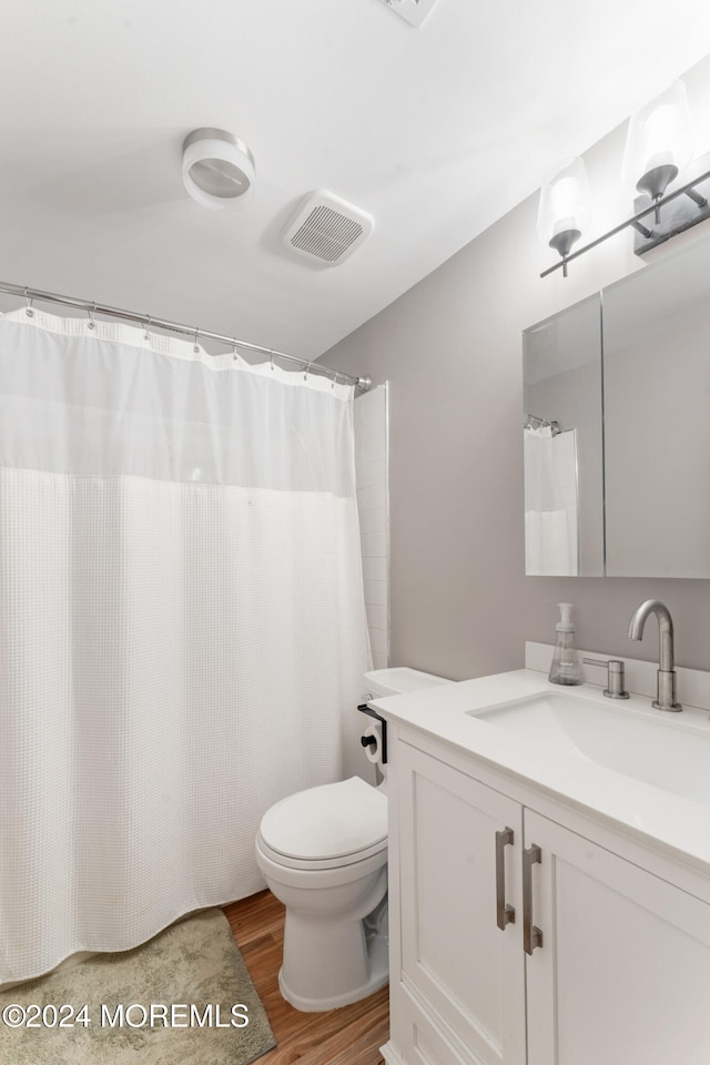 bathroom featuring vanity, toilet, and hardwood / wood-style floors