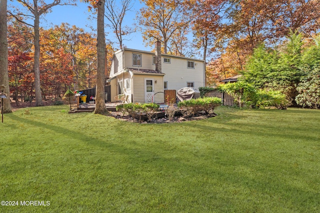 rear view of property with a yard and a deck