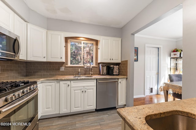 kitchen featuring white cabinetry, backsplash, stainless steel appliances, and sink