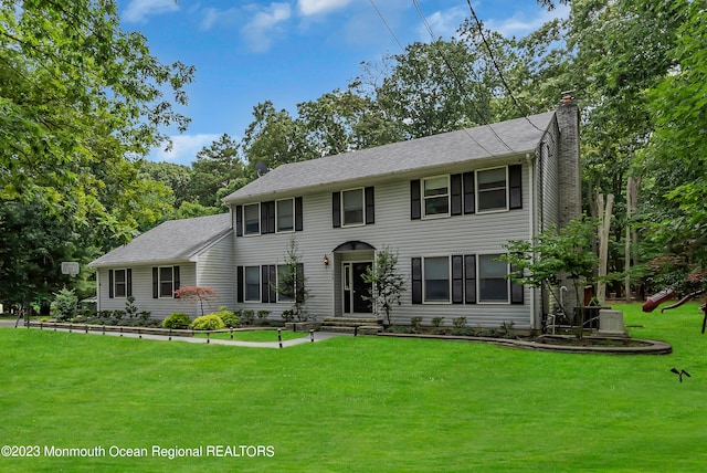 colonial home with cooling unit and a front lawn