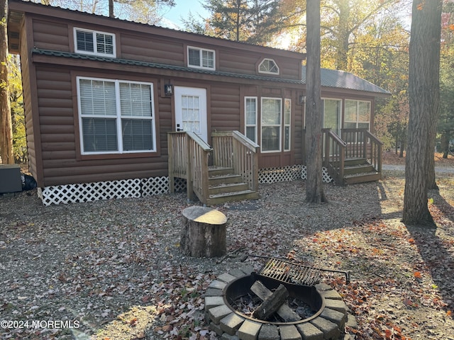 view of front of property featuring faux log siding and an outdoor fire pit
