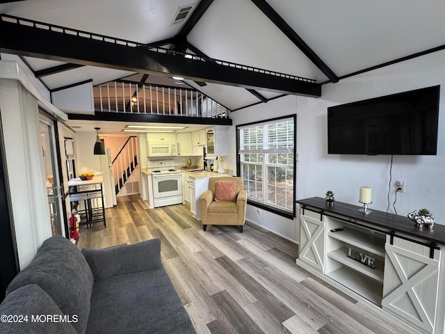 living room featuring beam ceiling, sink, light hardwood / wood-style flooring, and high vaulted ceiling