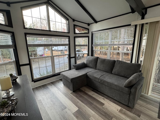 sunroom featuring a wealth of natural light and vaulted ceiling with beams