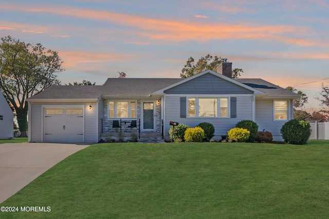 ranch-style house with a garage and a lawn