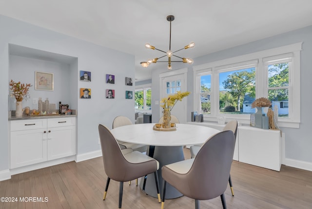 dining space with a notable chandelier, hardwood / wood-style flooring, and plenty of natural light