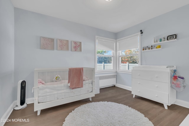 bedroom featuring dark wood-type flooring and radiator heating unit